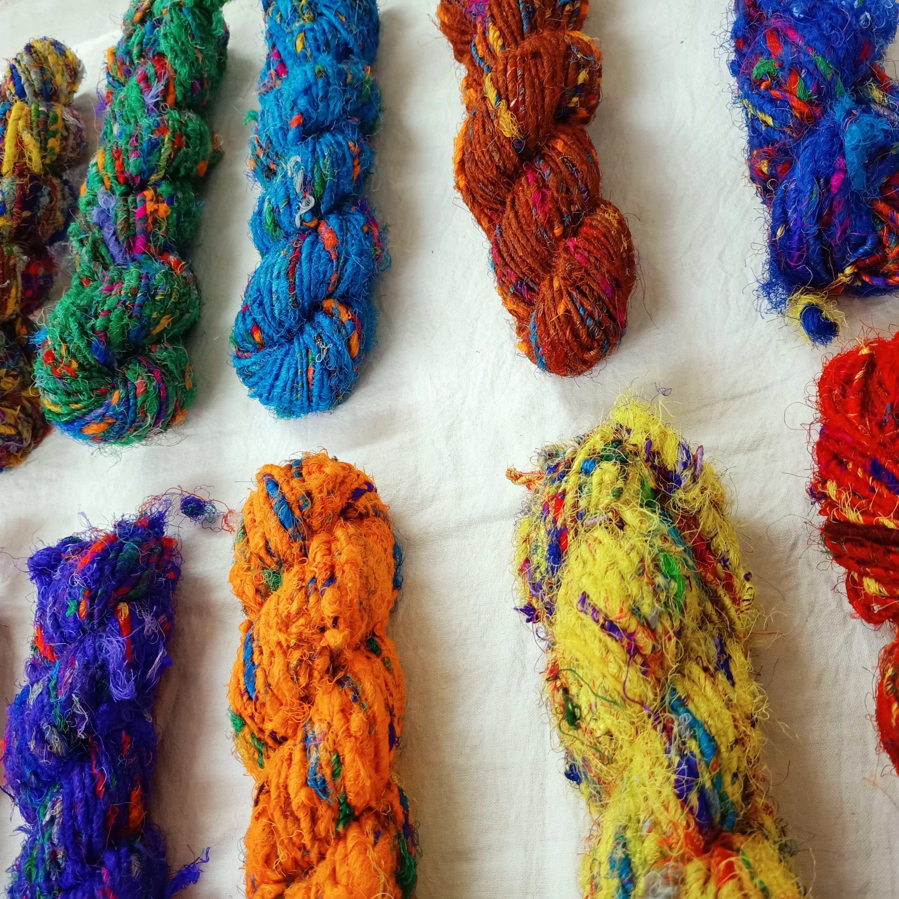 multi colored sari silk fuzzy  ribbon yarns made recycled sari fabrics ideal for textile artists and yarn stores for resale