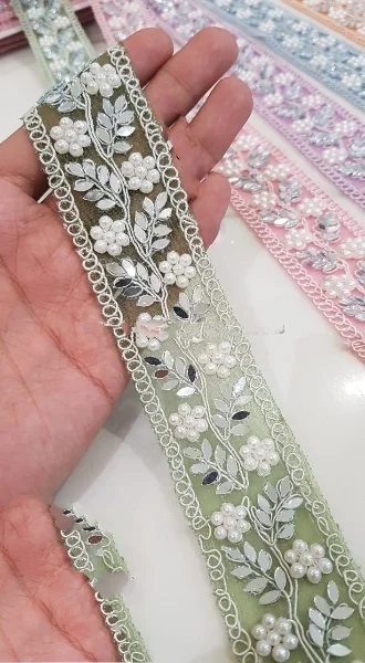 custom made machine embroidered ribbons & laces in various designs & colours for wedding dresses on net fabric with curly border