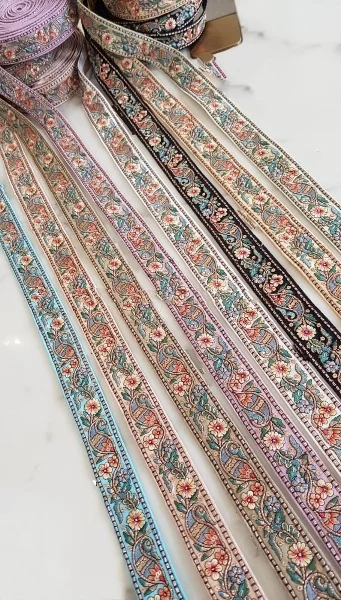 custom made machine embroidered ribbons & laces in various designs & colours for wedding dresses on net fabric with curly border