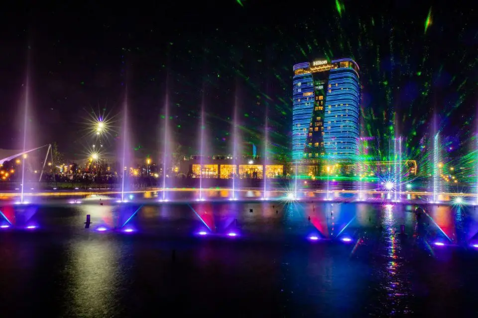 A large outdoor music and dancing water fountain show featuring laser lights, water screen mapping, video projections, fireworks