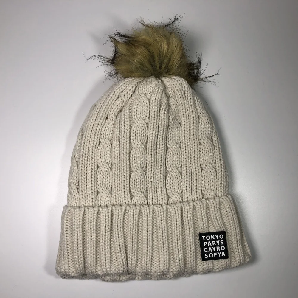 Women fashion beige faux fur pom pom skull bobble hats for children and adults Custom embroidery label acrylic cable knit beanie