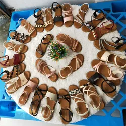 Множество дешевых женских туфель на плоской подошве и женские сандалии и тапочки