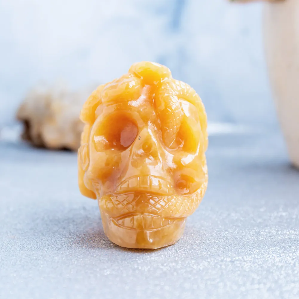 Wholesale natural high quality hand carved orange calcite crystal skulls folk carfts with snake for Halloween decoration