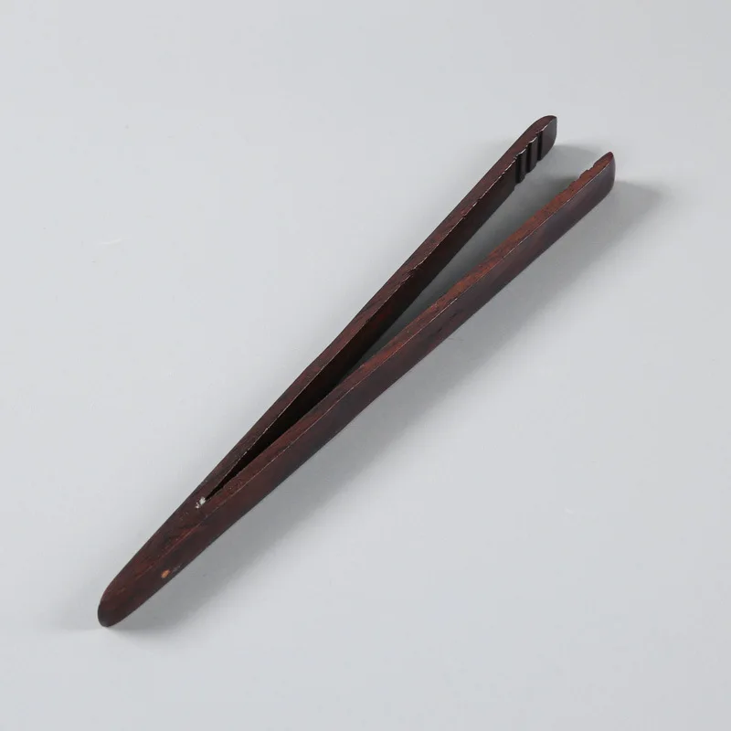 straight Tea with ebony chicken wings Wooden teacup with tea pliers Bamboo and wood tea tools