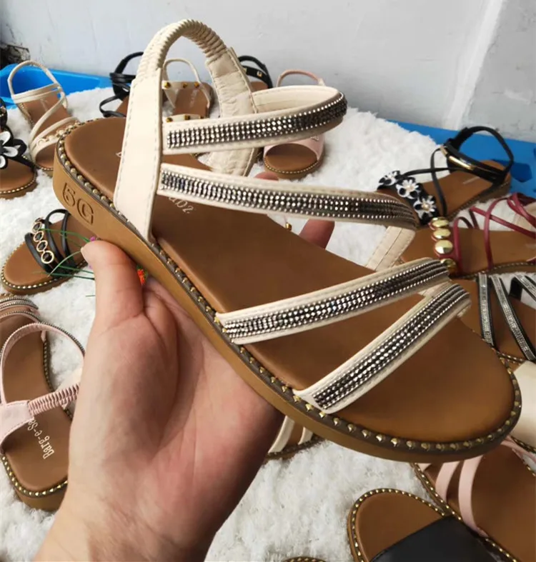 Множество дешевых женских туфель на плоской подошве и женские сандалии и тапочки