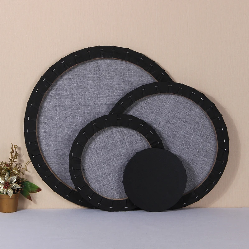 
An artist paints canvas on a blank cotton canvas board with a circular cotton wood frame 