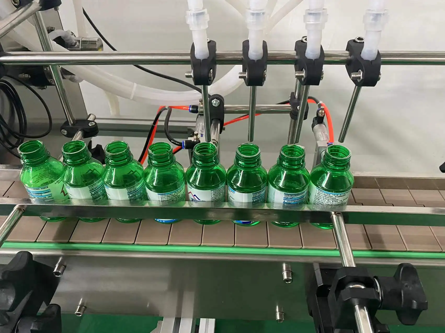 Automatic 4 Heads Liquid Filling Machine Magnetic Pump Filler With Chain Conveyor Platform