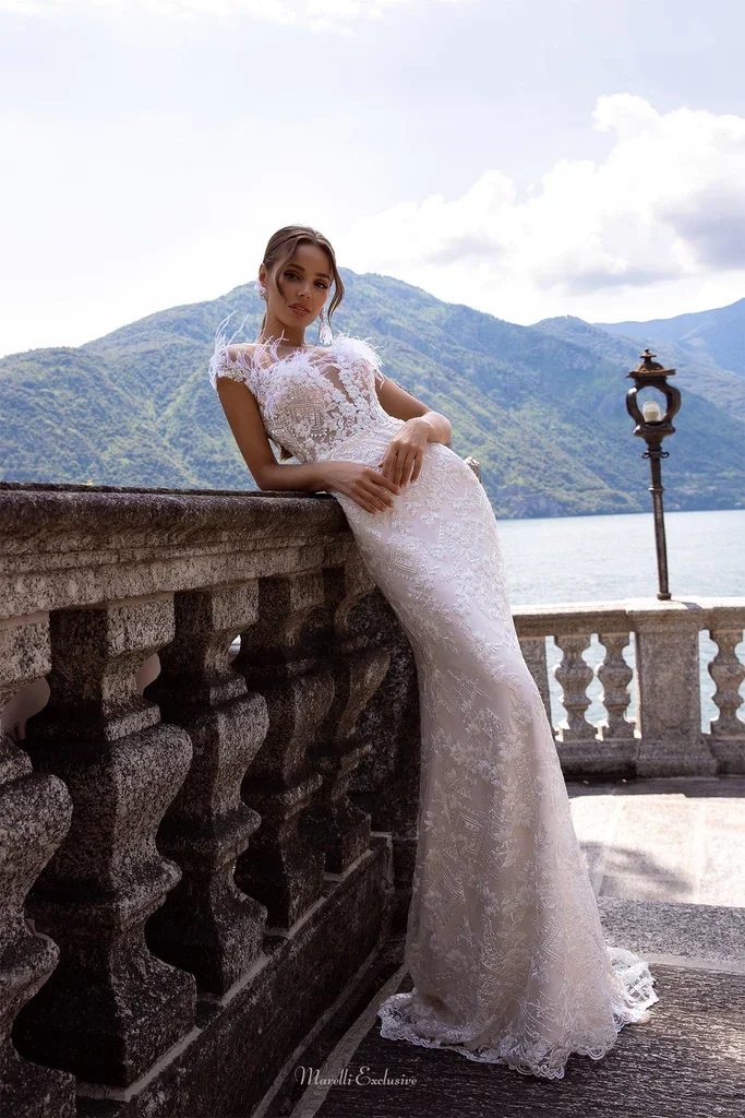 A tight-fitting long tail wedding dress with a removable tulle train created by layers of tulle Decorated swan feathers