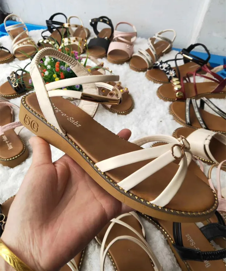 Множество дешевых женских туфель на плоской подошве и женские сандалии и тапочки