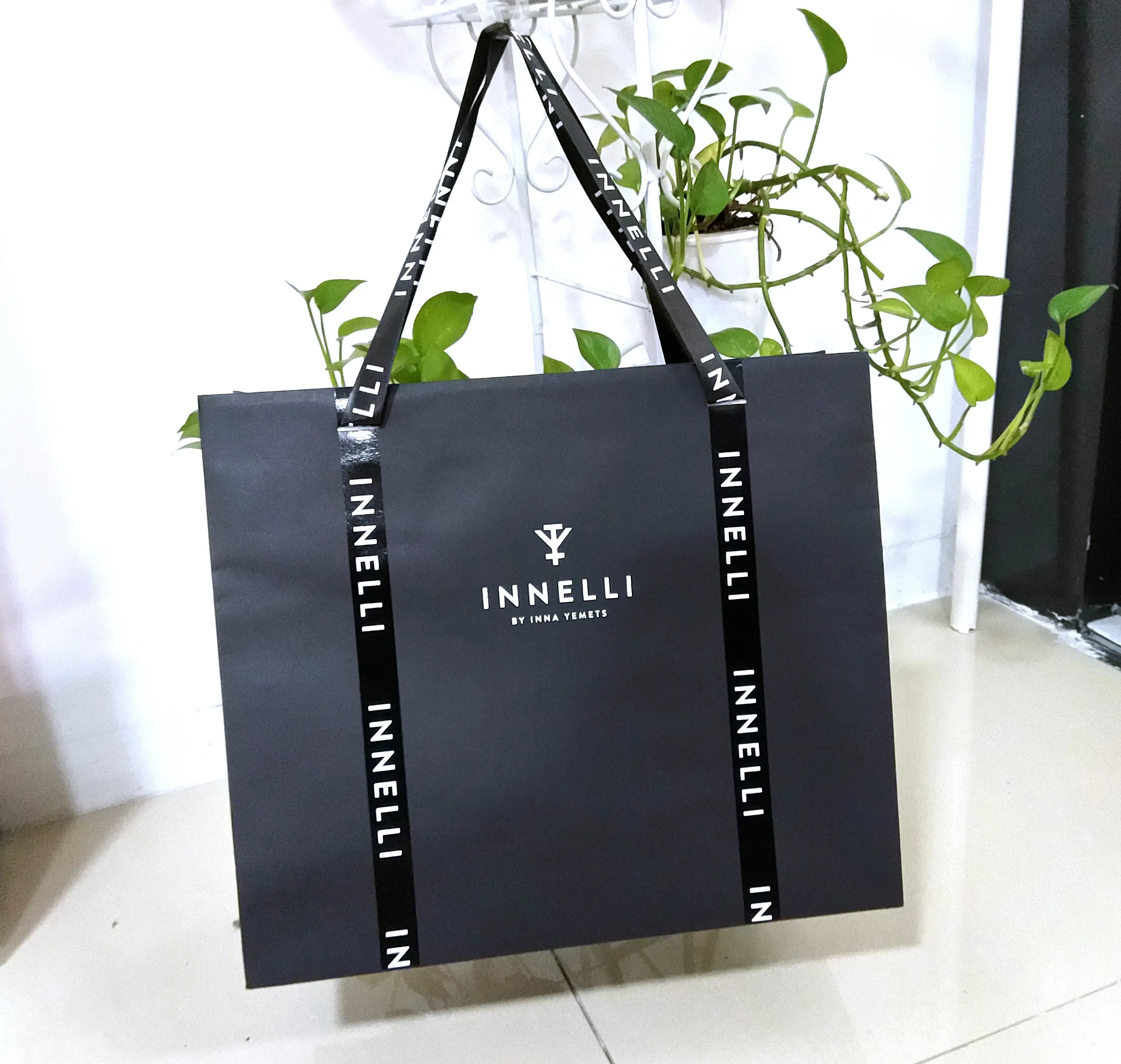 Factory custom printed matte black shopping paper bag with ribbon handle paper packaging custom logo