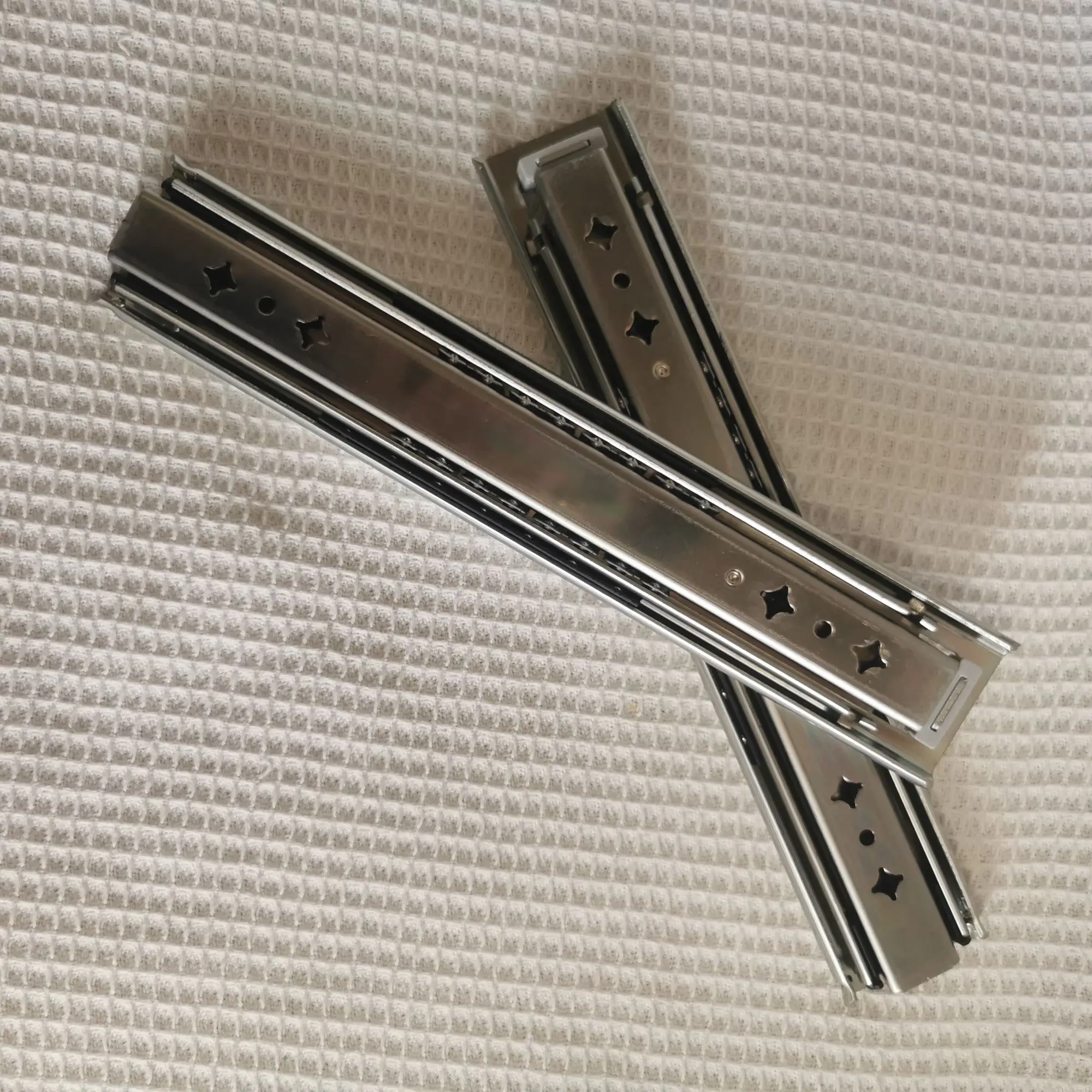 Hidden drawer slides are installed at the bottom of the heavy-duty drawer rails under the stairs