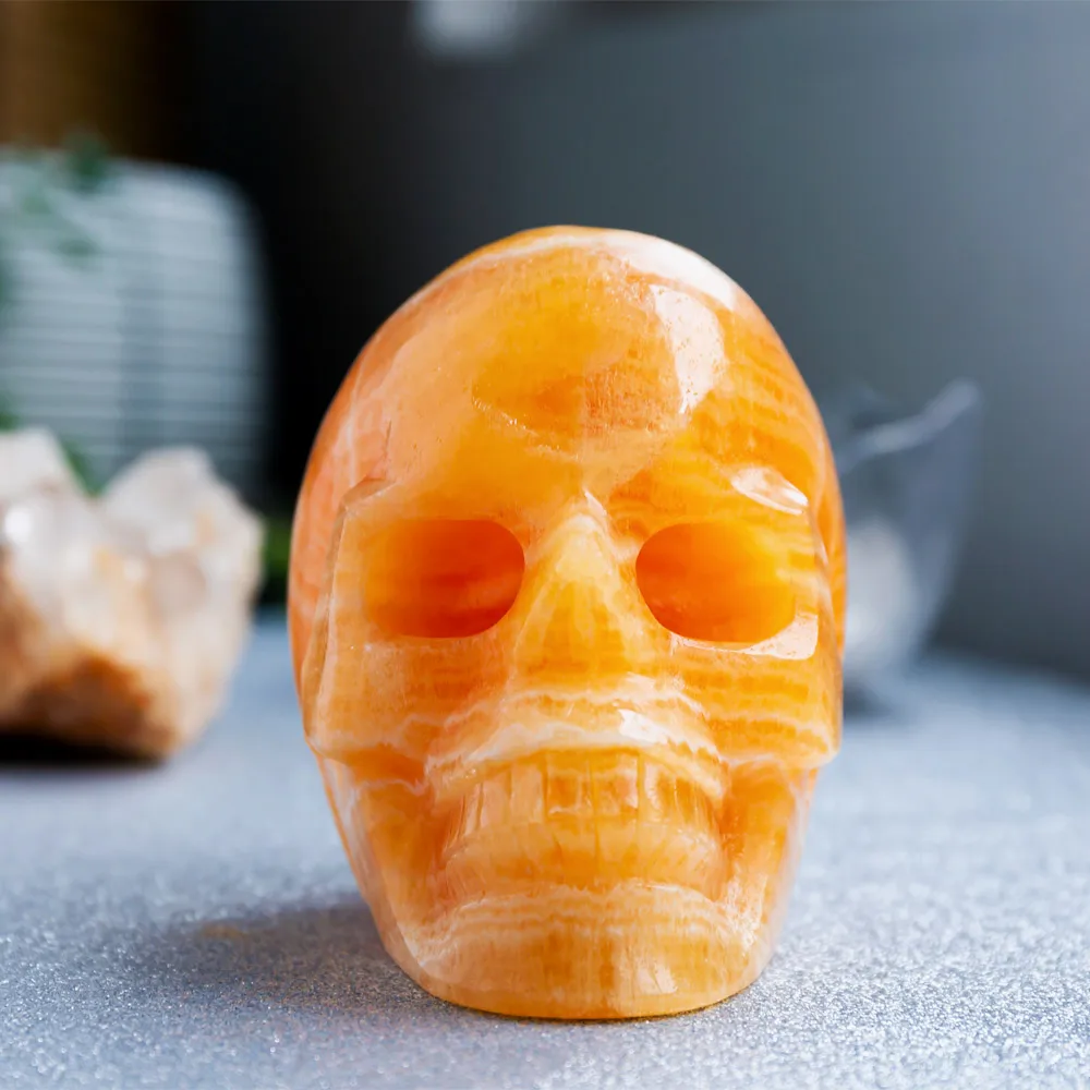 Wholesale Natural Reiki Gemstone Hand Carved Orange Calcite Crystal Skulls Crafts Healing Stone For Home Decoration