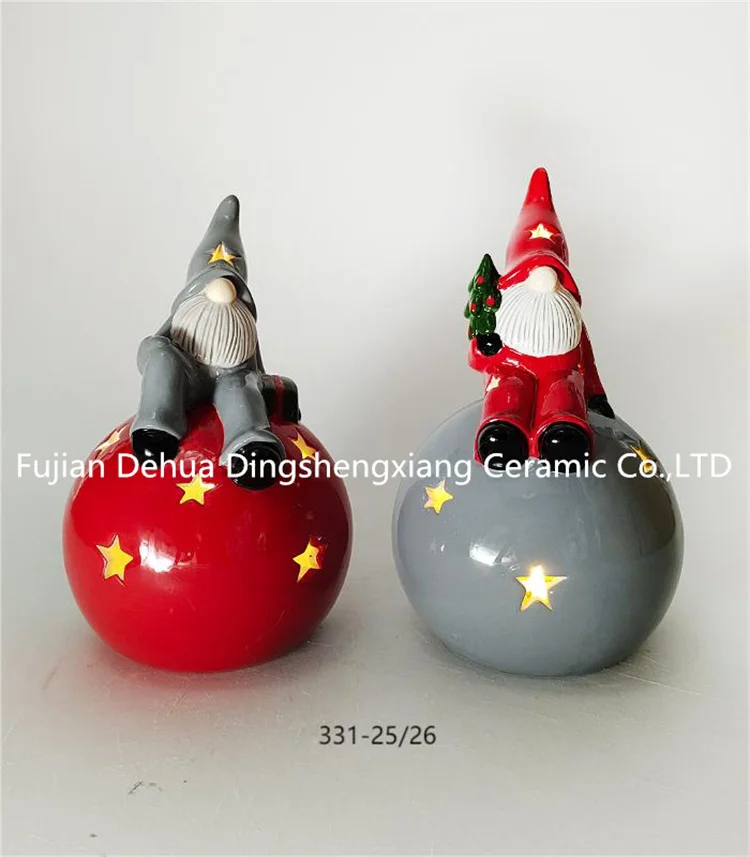 Hand-painted ceramic gnome santa claus with present for holiday decoration