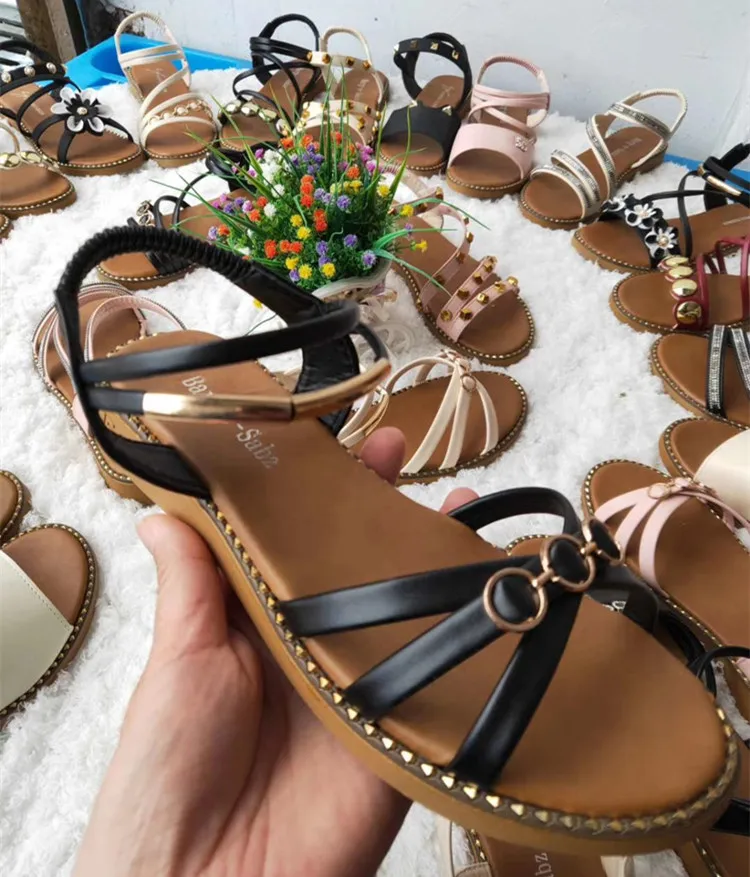 Множество дешевых женских туфель на плоской подошве и женские сандалии и тапочки