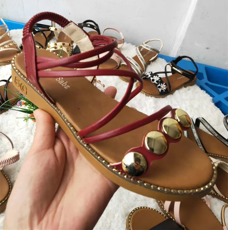 Множество дешевых женских туфель на плоской подошве и женские сандалии и тапочки