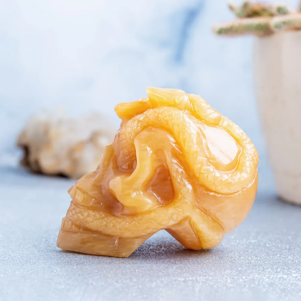 Wholesale natural high quality hand carved orange calcite crystal skulls folk carfts with snake for Halloween decoration
