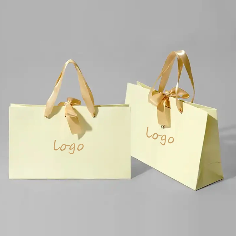 Factory wholesale custom printed brand logo bow tie design promotion luxury clothing gift shopping paper bag with handle