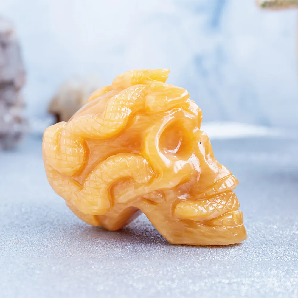 Wholesale natural high quality hand carved orange calcite crystal skulls folk carfts with snake for Halloween decoration