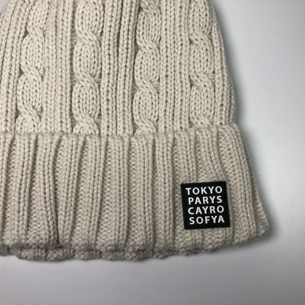 Women fashion beige faux fur pom pom skull bobble hats for children and adults Custom embroidery label acrylic cable knit beanie