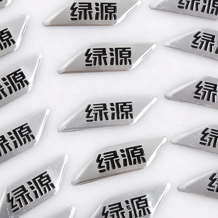 
outdoor brushed aluminum metal decal with black embossed company logo and adhesive on back 