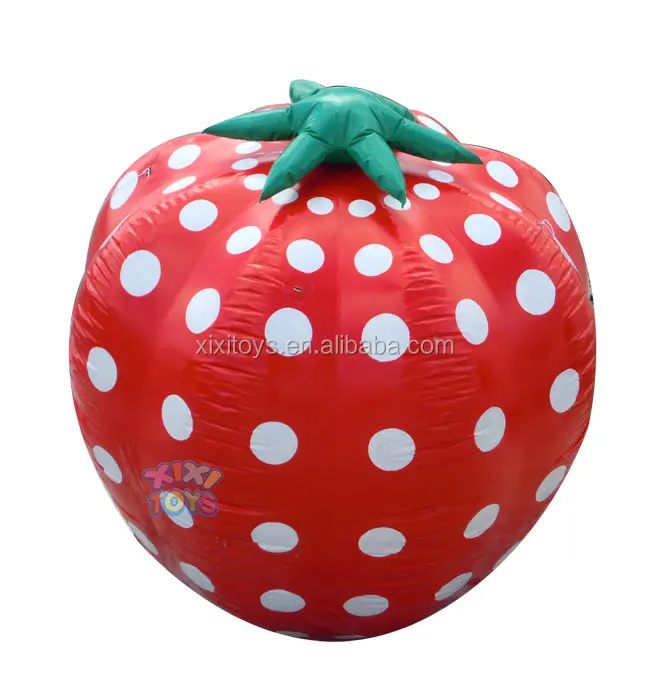 Large inflatable strawberry balloon on ground, advertising fruit inflatable character cartoon