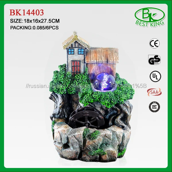 В помещении дома фонтан с стеклянный шар и колесо