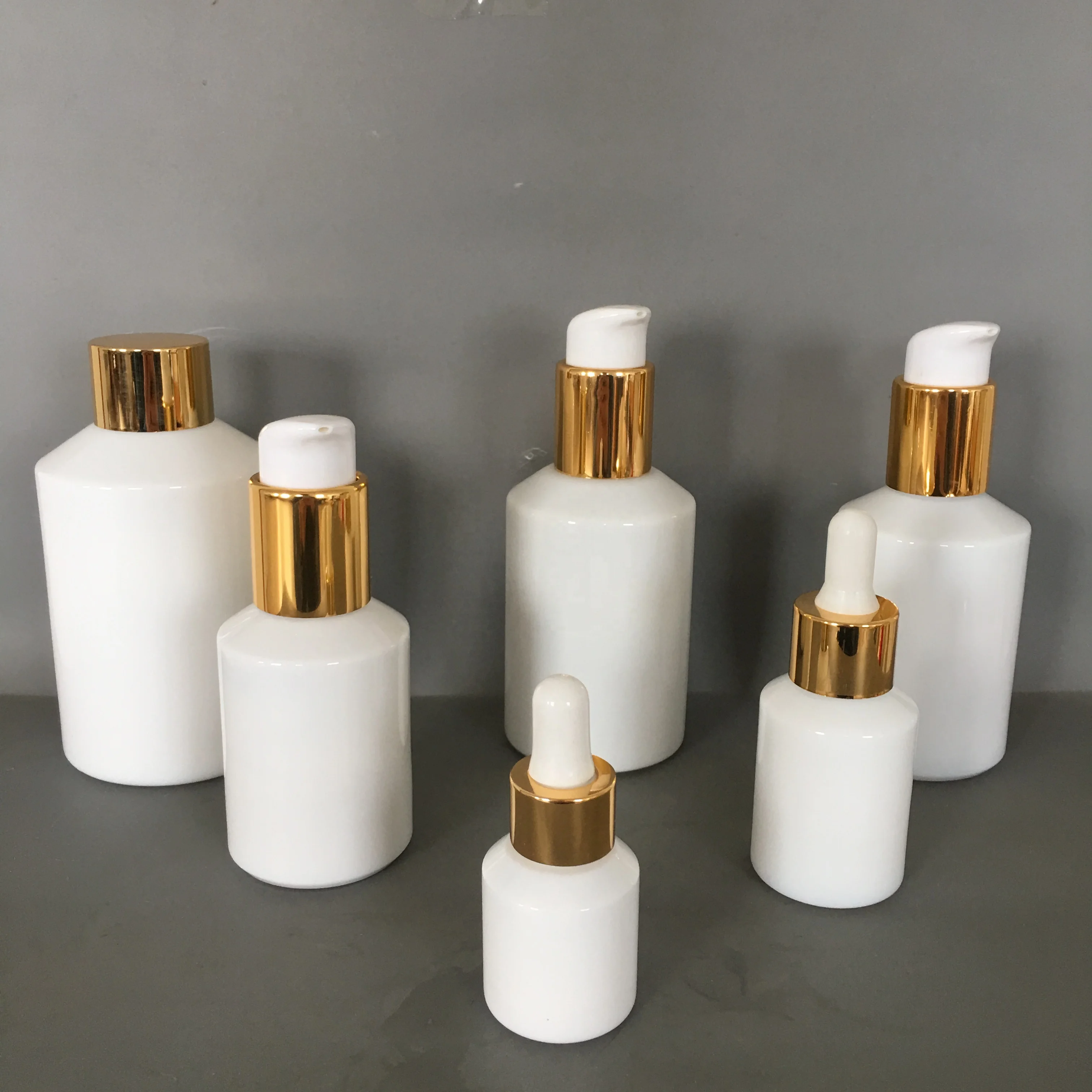 Cosmetic packaging slant shoulder white glass bottle and jar series with gold lid/pump/dropper cosmetic lotion bottle products
