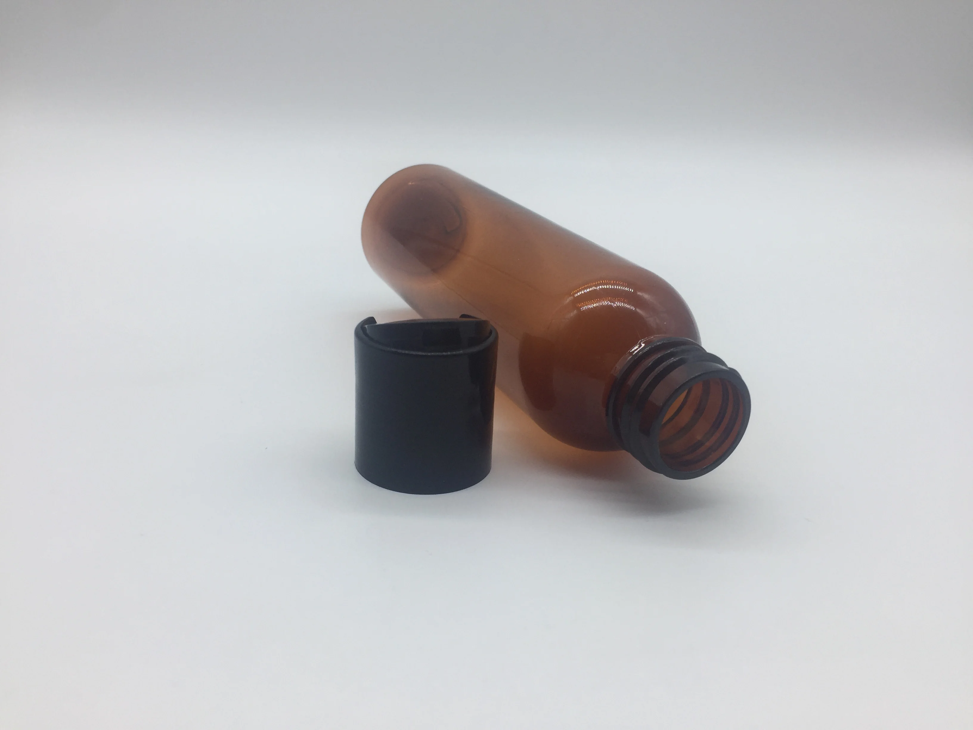 
4OZ amber cosmo round PET bottle with disc top cap 