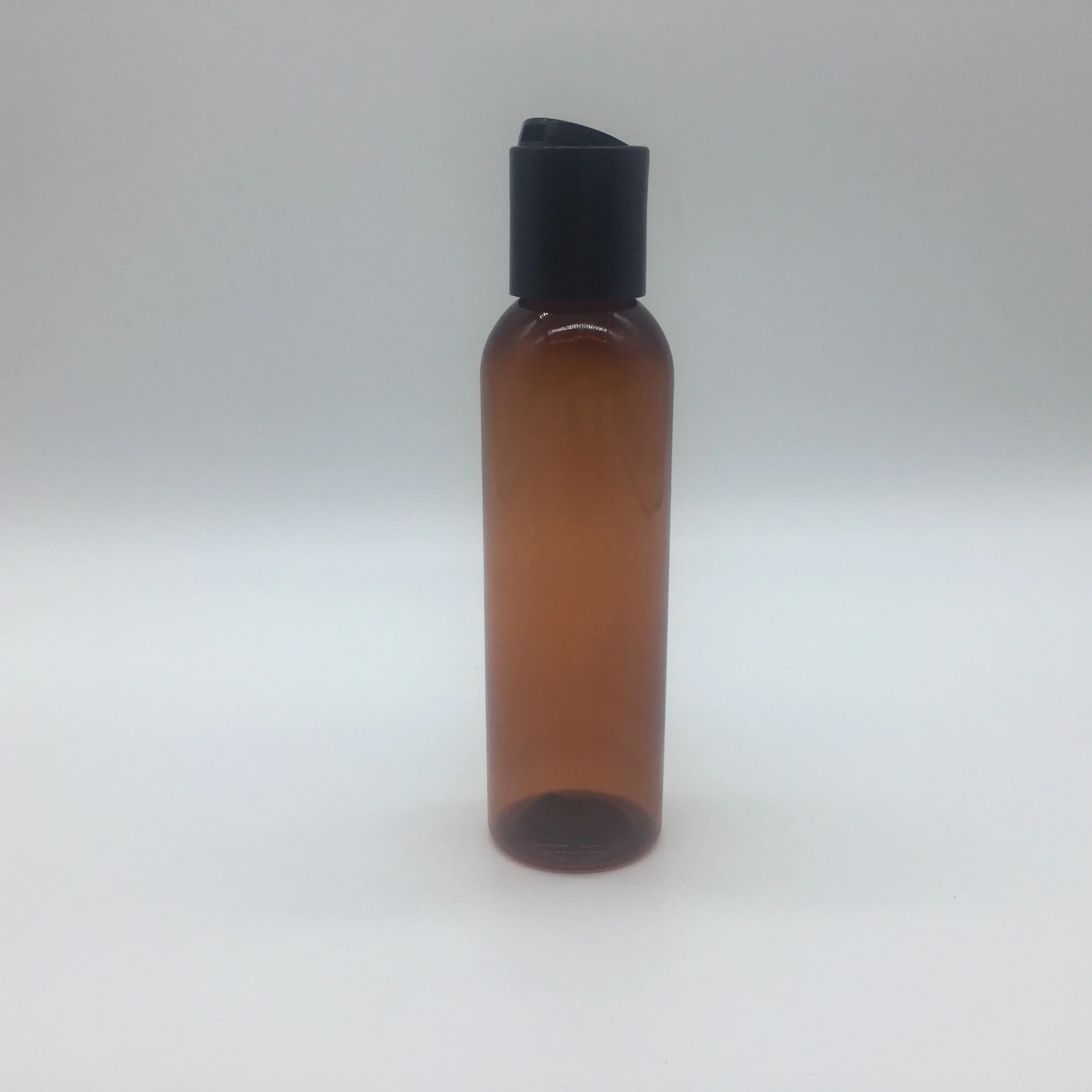 
4OZ amber cosmo round PET bottle with disc top cap 