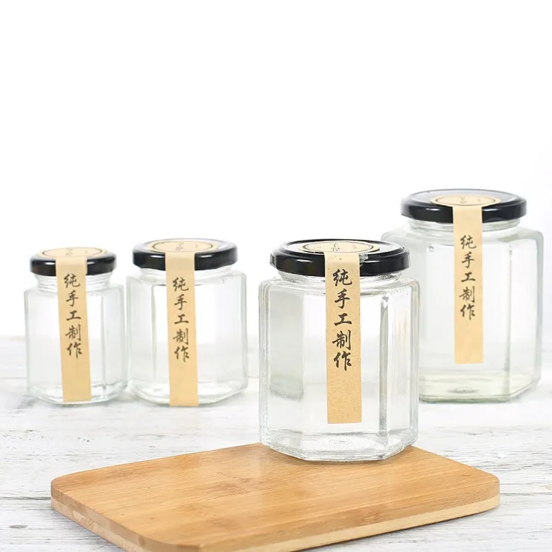 Wholesale different sizes hexagon honey glass jar glass storage bottle with black screw metal lid