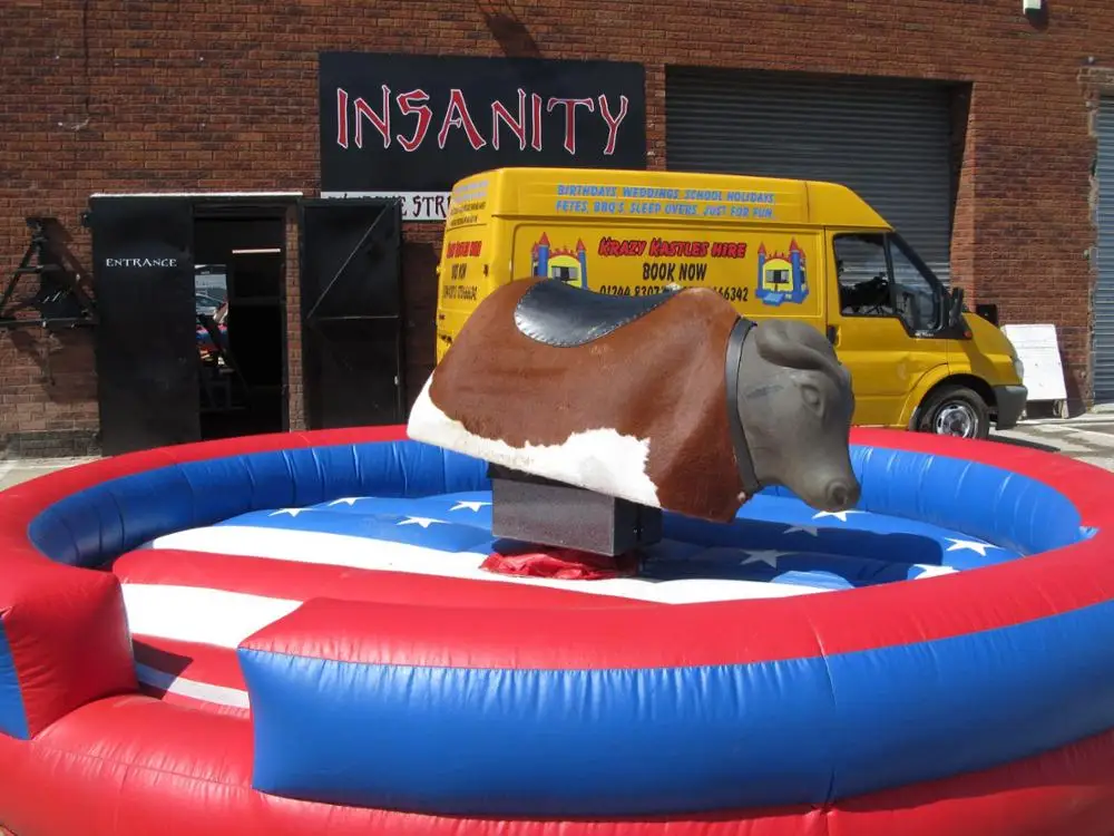 Giant Mechanical Rodeo Bull With Inflatable Mattress Interactive Game In Amusement Park