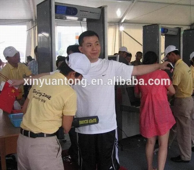 
security guard hand holding mini metal detector for public safety checking 