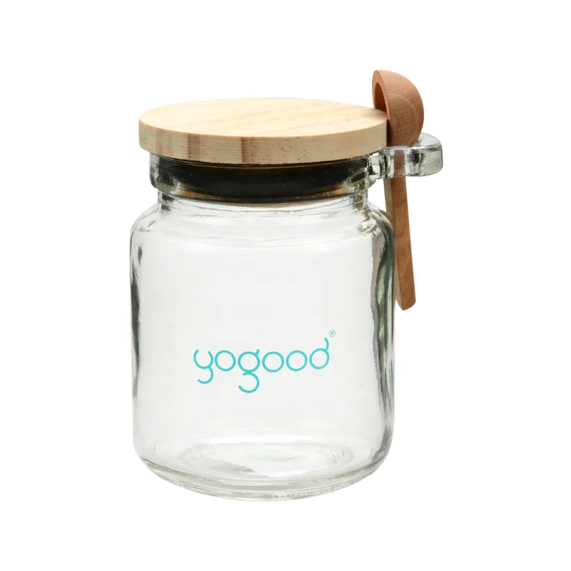 Honey glass jar with wooden lid and spoon