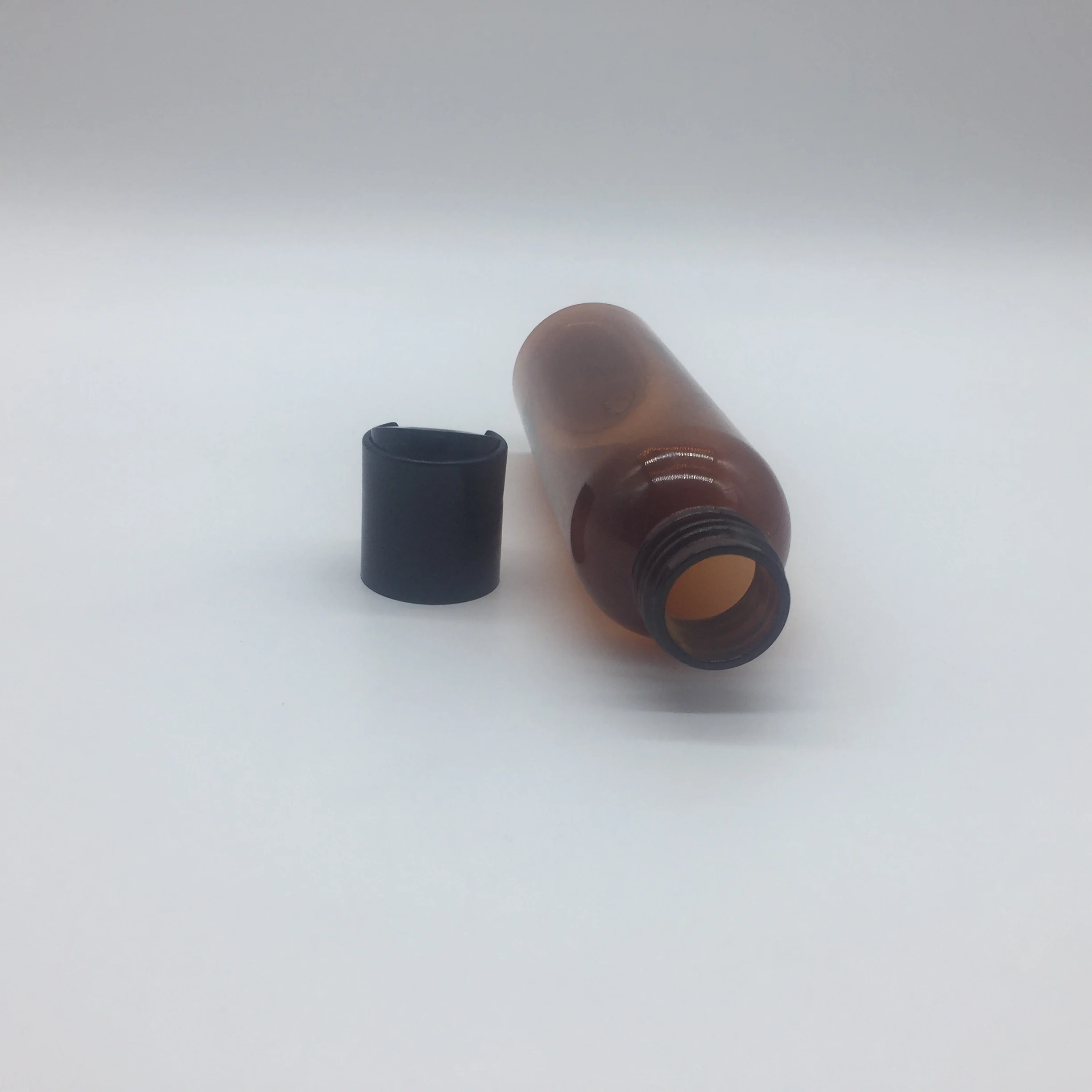 
4OZ amber cosmo round PET bottle with disc top cap 