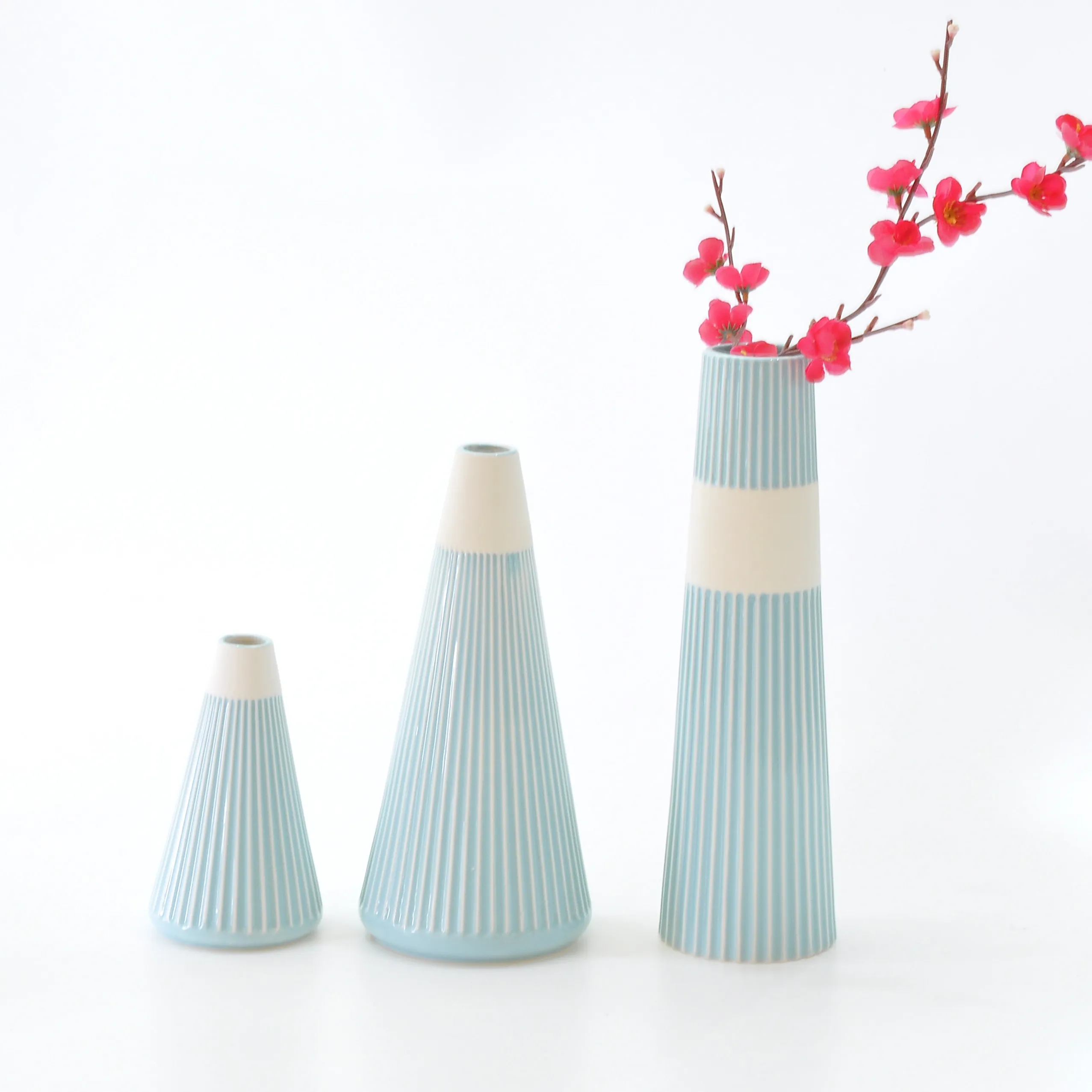 Modern decorative slim ceramic vases with flowers in glaze with rubbing