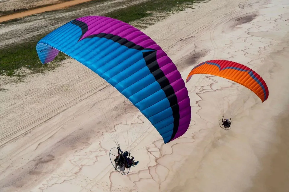 The orange remote-controlled sports aircraft paramotor can be used by two people.