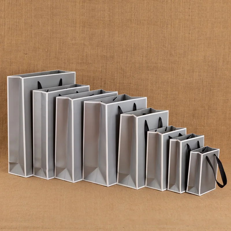Wholesale custom printed grey and white cardboard stock gift clothing shopping paper bag with your own ribbon handle logo