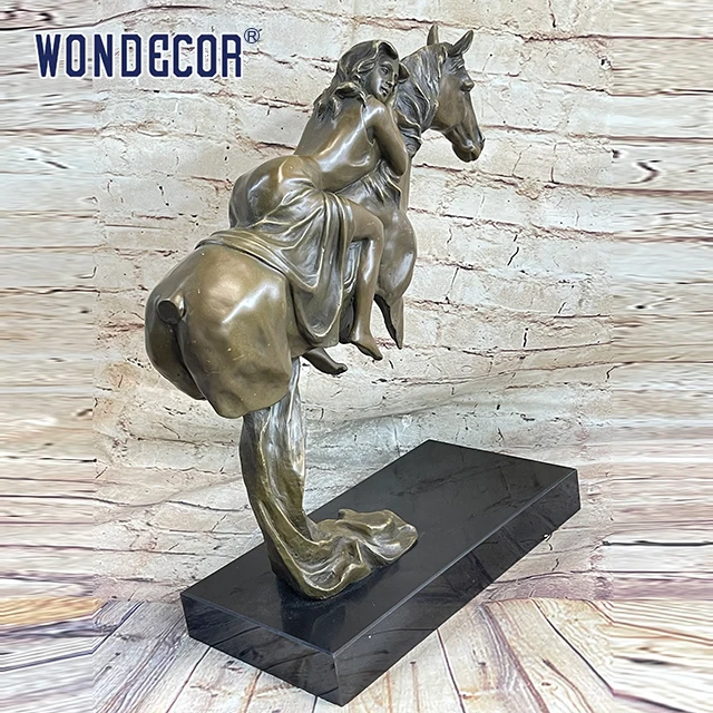 A copper sculpture of a young girl on a large metal art horse back outdoors
