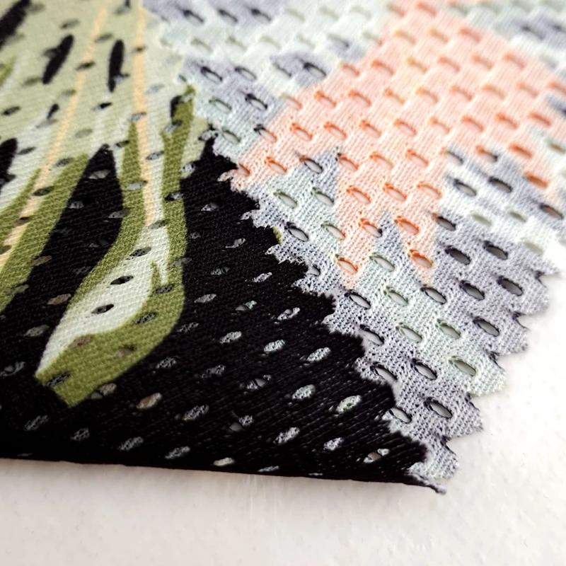 Breathable 100% polyester wrap knit custom leaf printed 130GSM eyelet sports mesh fabric for basketball tshirt