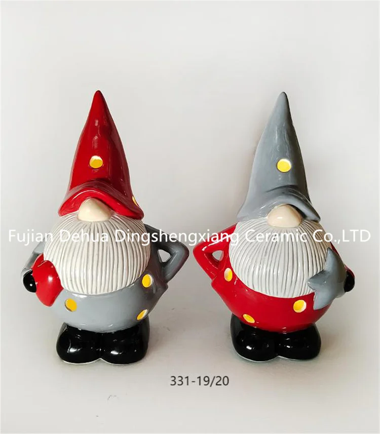 Hand-painted ceramic gnome santa claus with present for holiday decoration