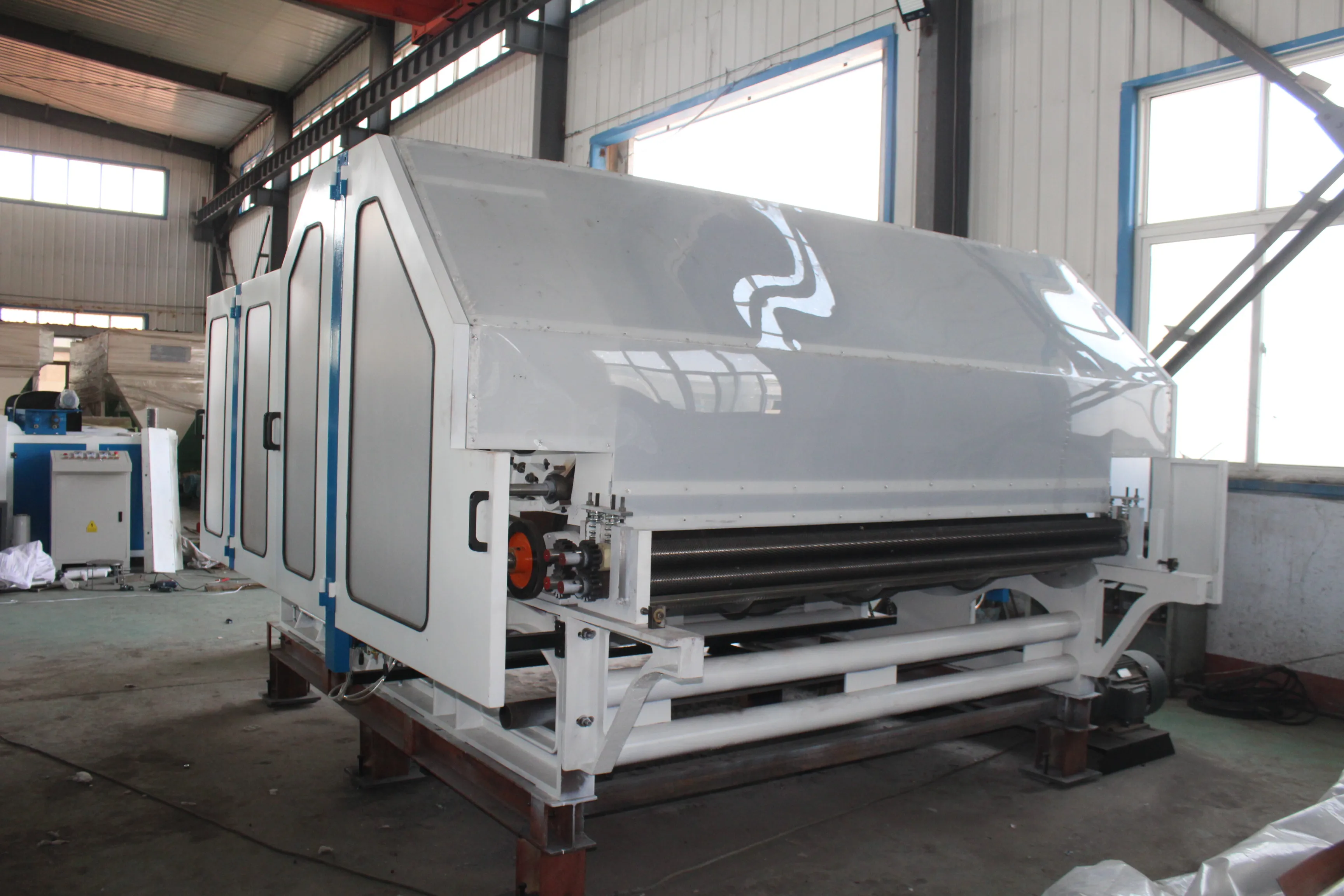 The non-woven fabric production machine combs the waste fiber polyester fiber into a web to make a felt carding machine