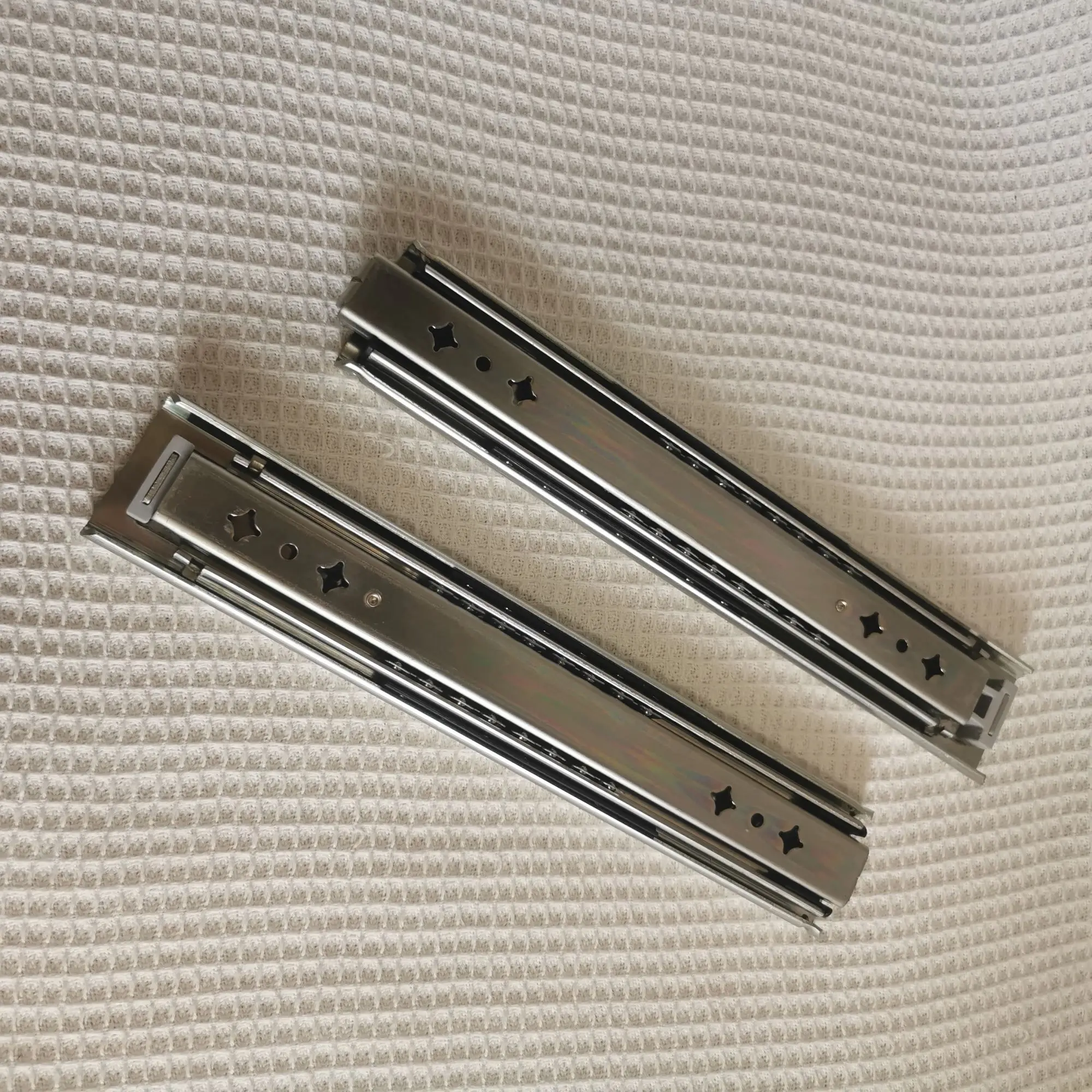 Hidden drawer slides are installed at the bottom of the heavy-duty drawer rails under the stairs