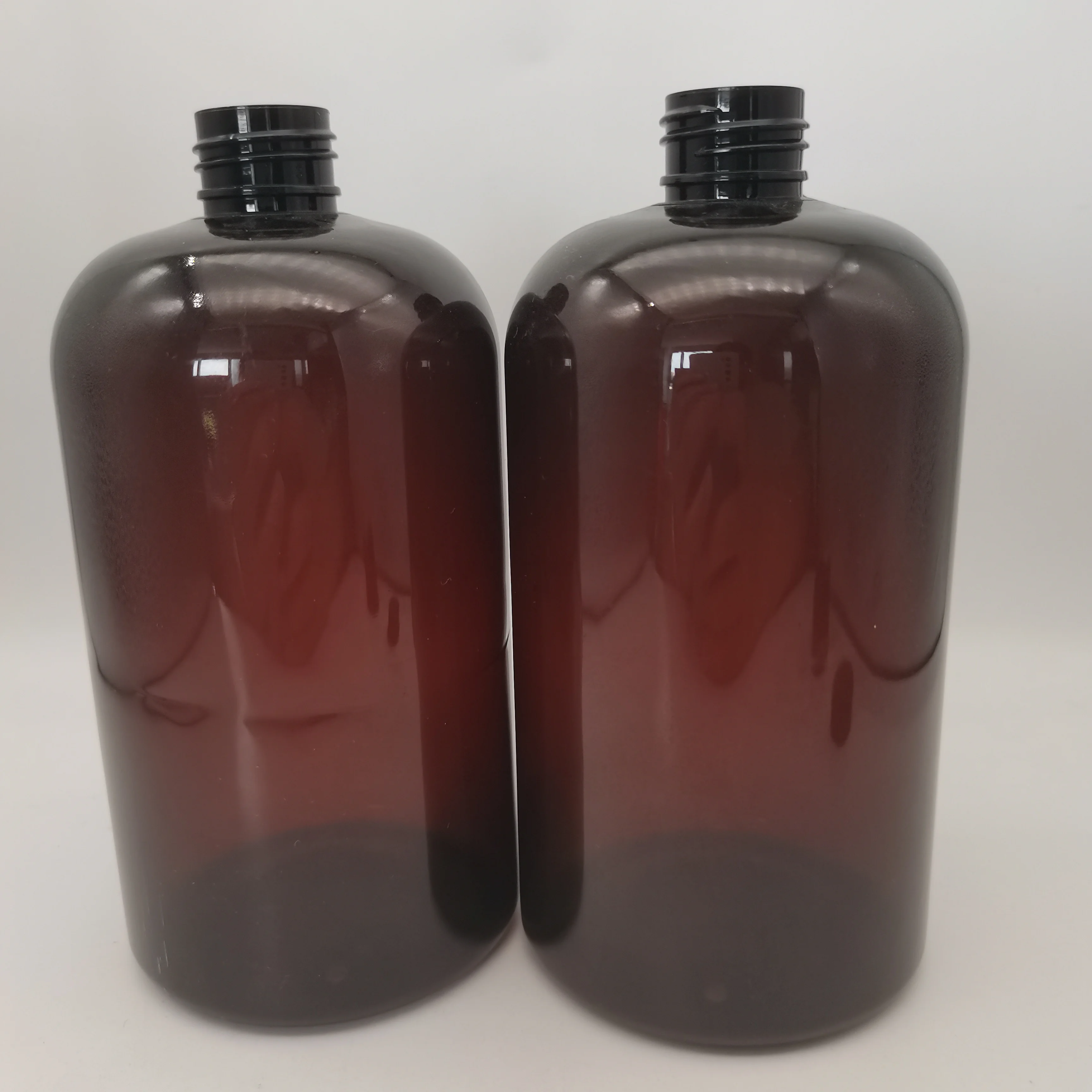 Dark amber Boston plastic bottle with black screw top and top