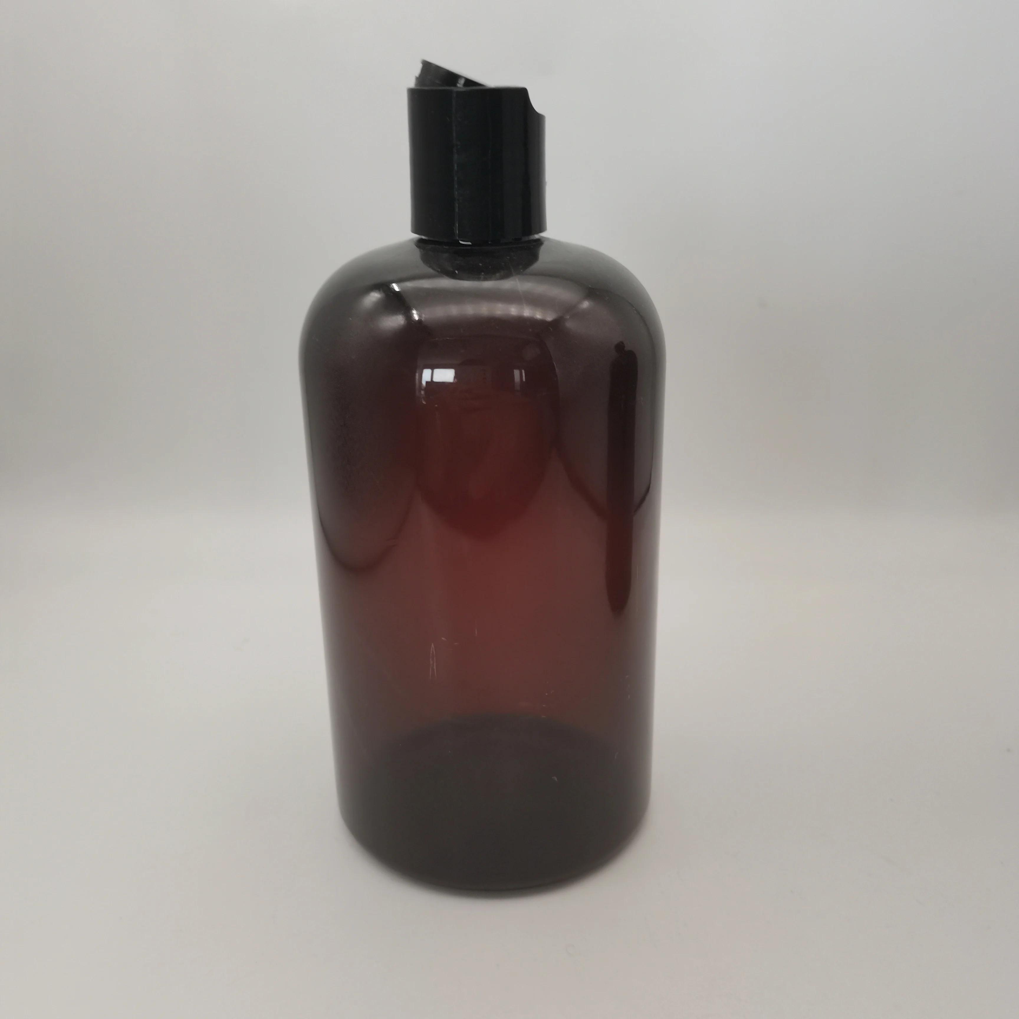 Dark amber Boston plastic bottle with black screw top and top