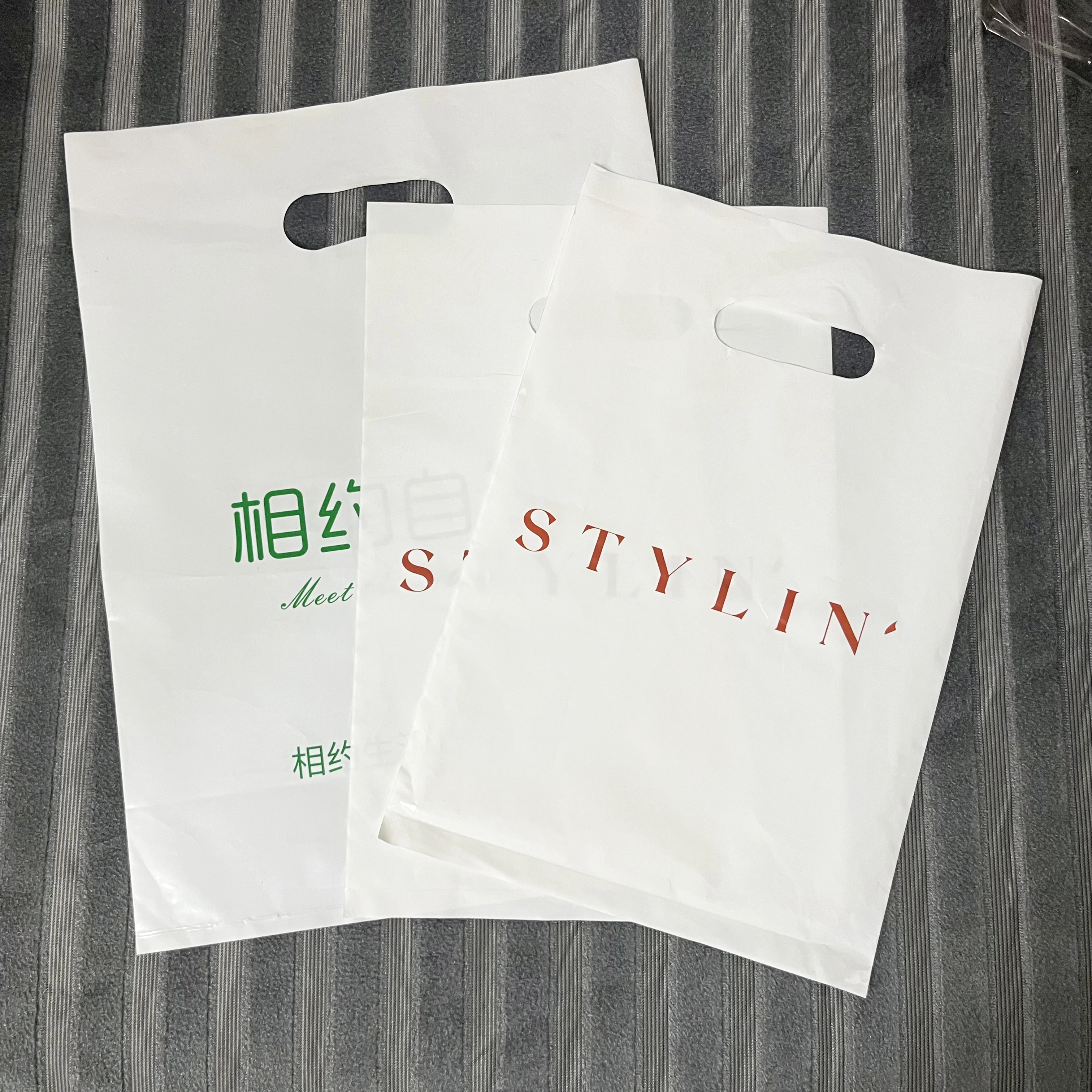 Hot Sell High Quality Printed  Plastic Packaging Bag Merchandise Handle Plastic Die Cut Bag For Clothes Shopping Bags With Logo
