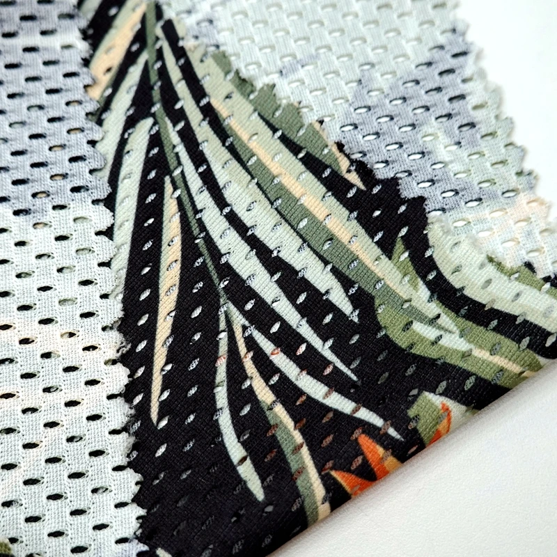 Breathable 100% polyester wrap knit custom leaf printed 130GSM eyelet sports mesh fabric for basketball tshirt