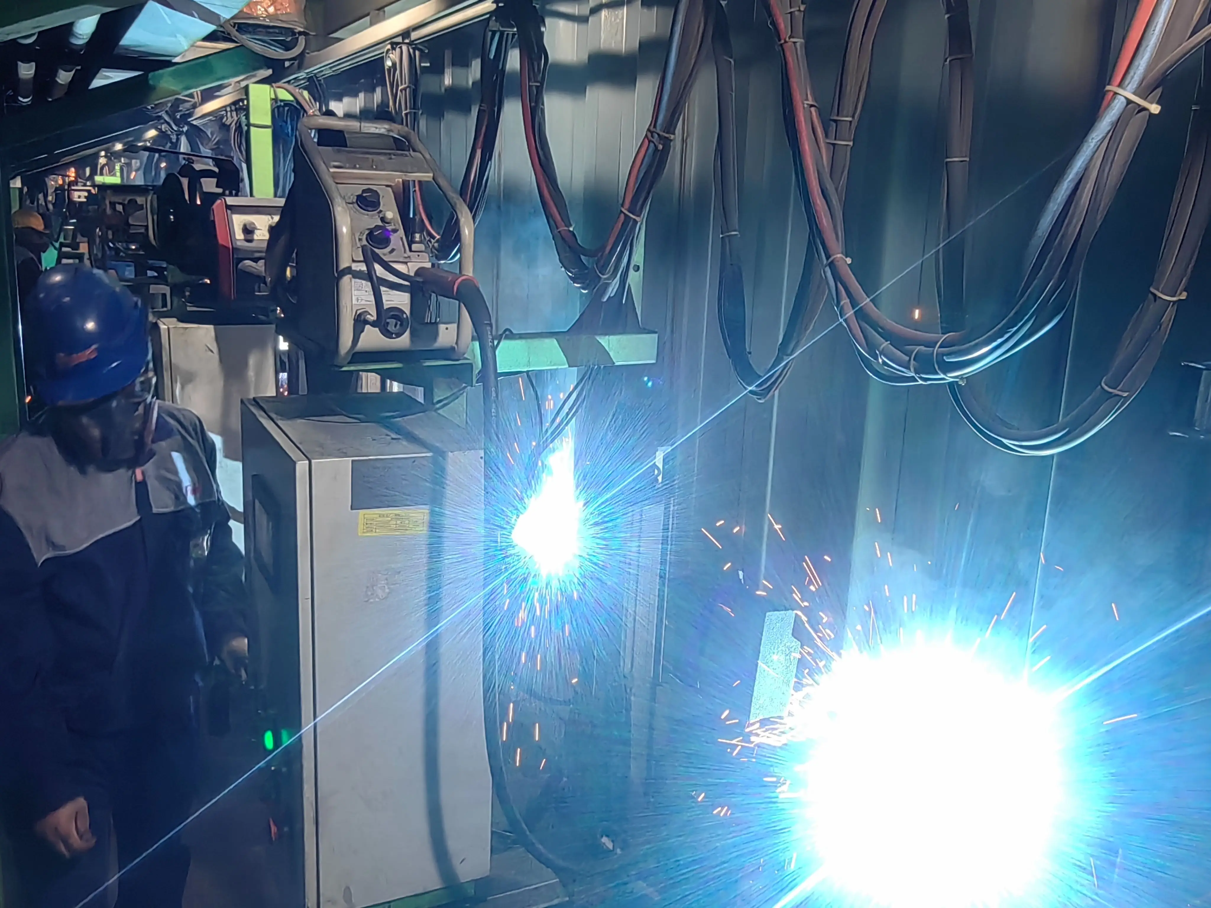 Low cost automatic welding equipment for corrugated beams in container manufacturing industry