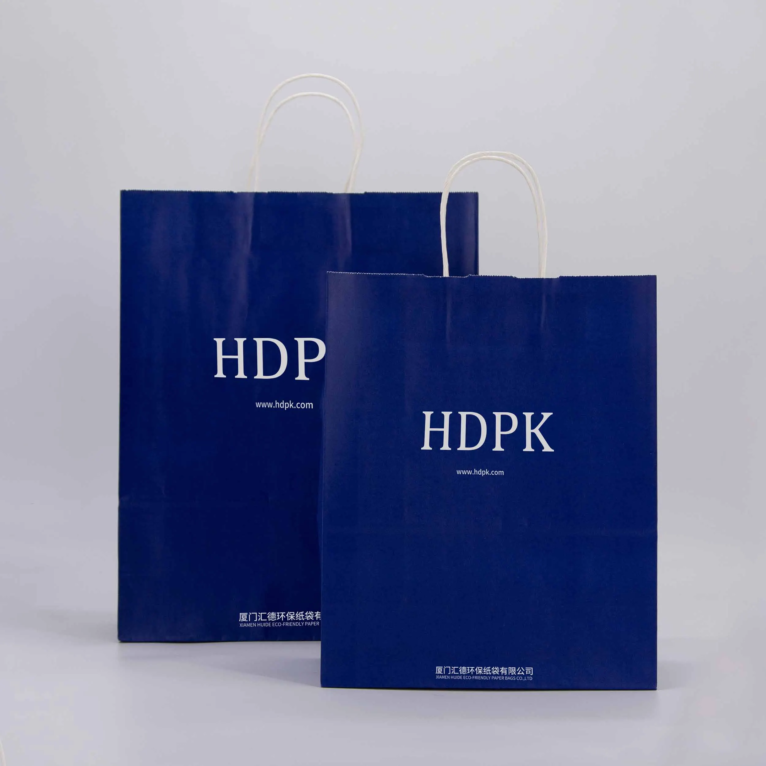 Настраиваемые синие бумажные пакеты HDPK с круглыми ручками из белой крафт-бумаги, прочные для премиальной упаковки