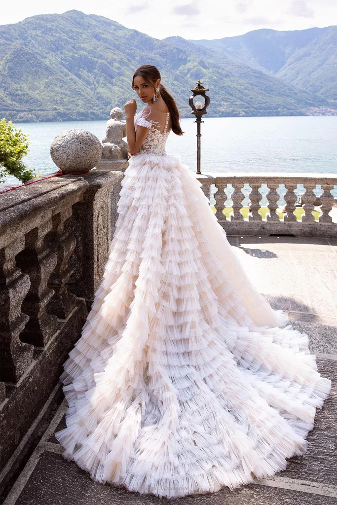 A tight-fitting long tail wedding dress with a removable tulle train created by layers of tulle Decorated swan feathers