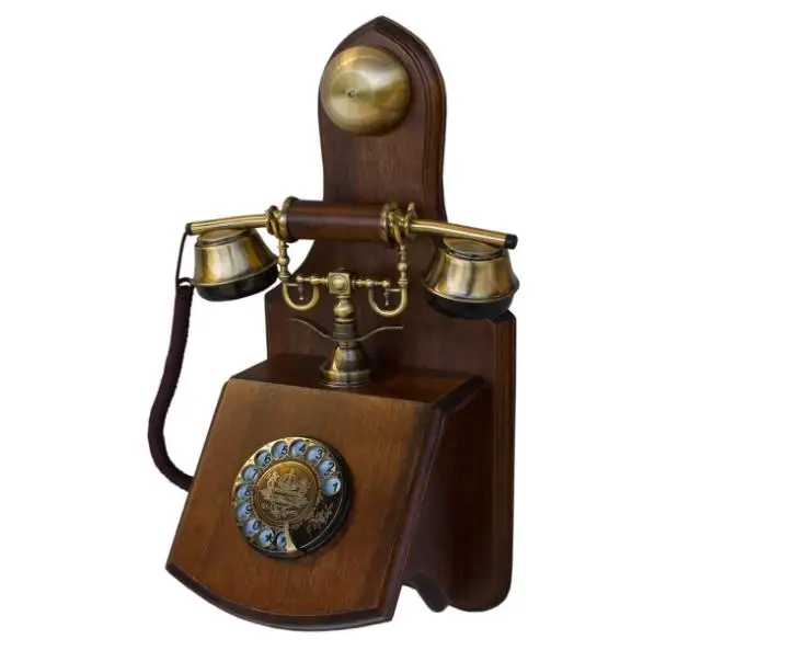The Old-Fashioned Wall-Mounted Wooden Retro Telephone with Metal Parts with Vintage Rotary Dial and Metal Bell